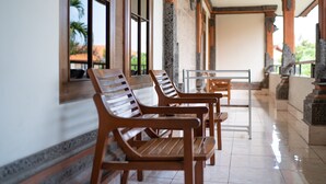 A corridor with wooden benches and a tiled floor. - Bendesa Accommodation (Kuta)