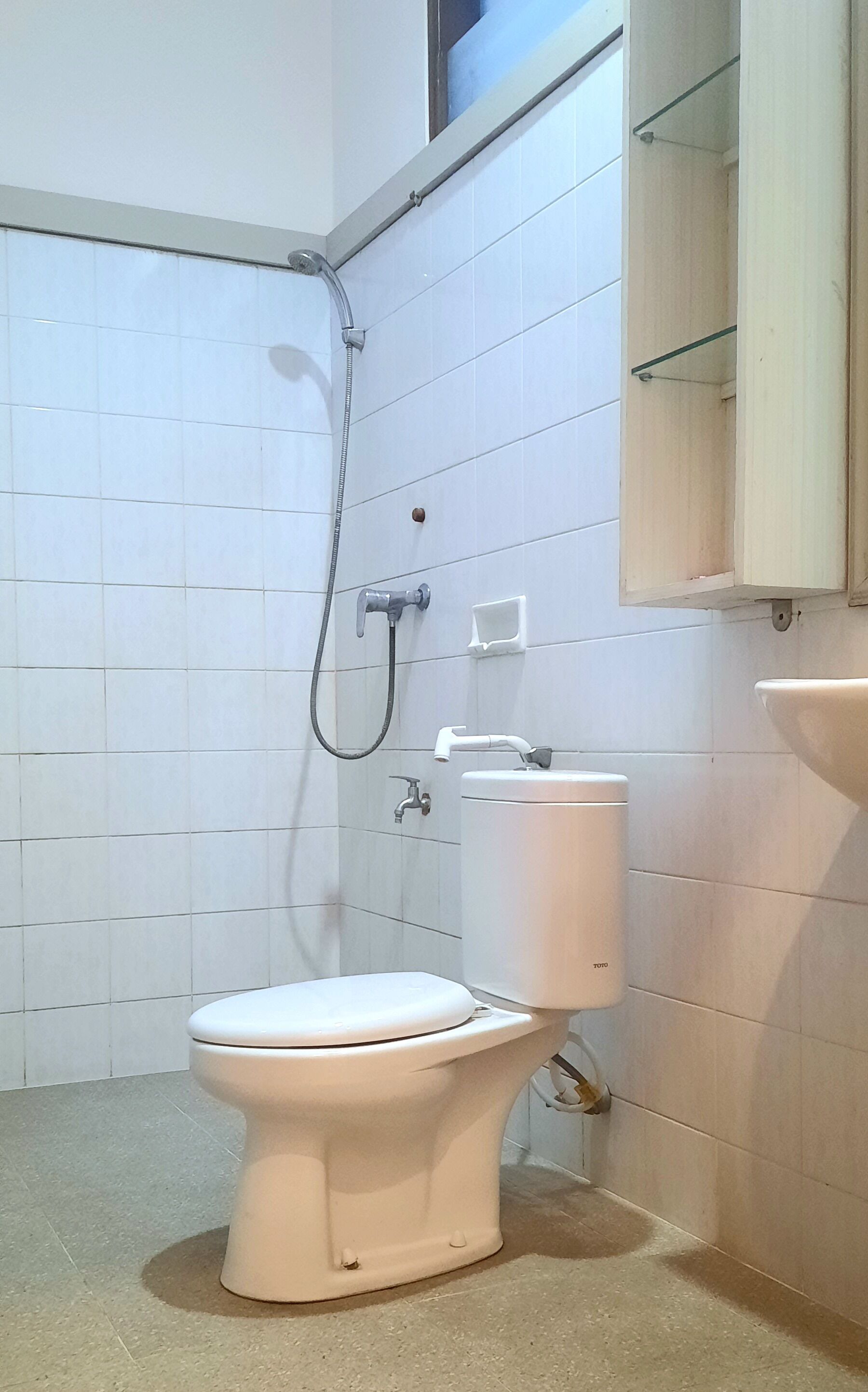 A bathroom with a toilet, a shower, and a sink.
