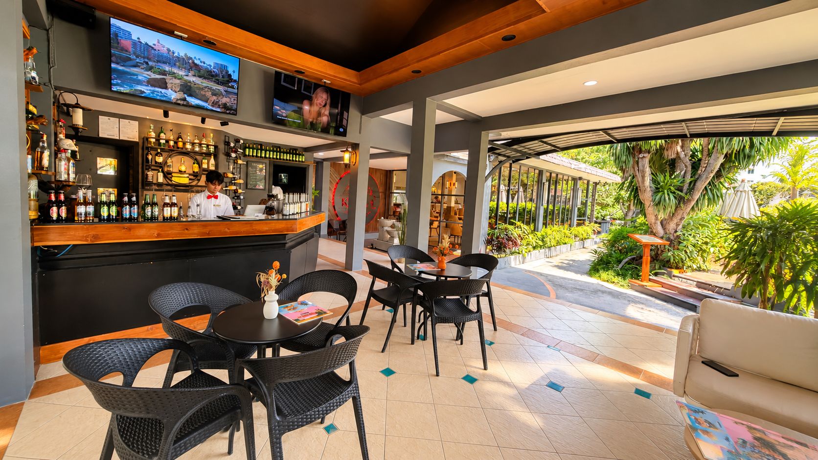 Eine Bar mit Theke, Sitzgelegenheiten und einem Fernsehbildschirm.