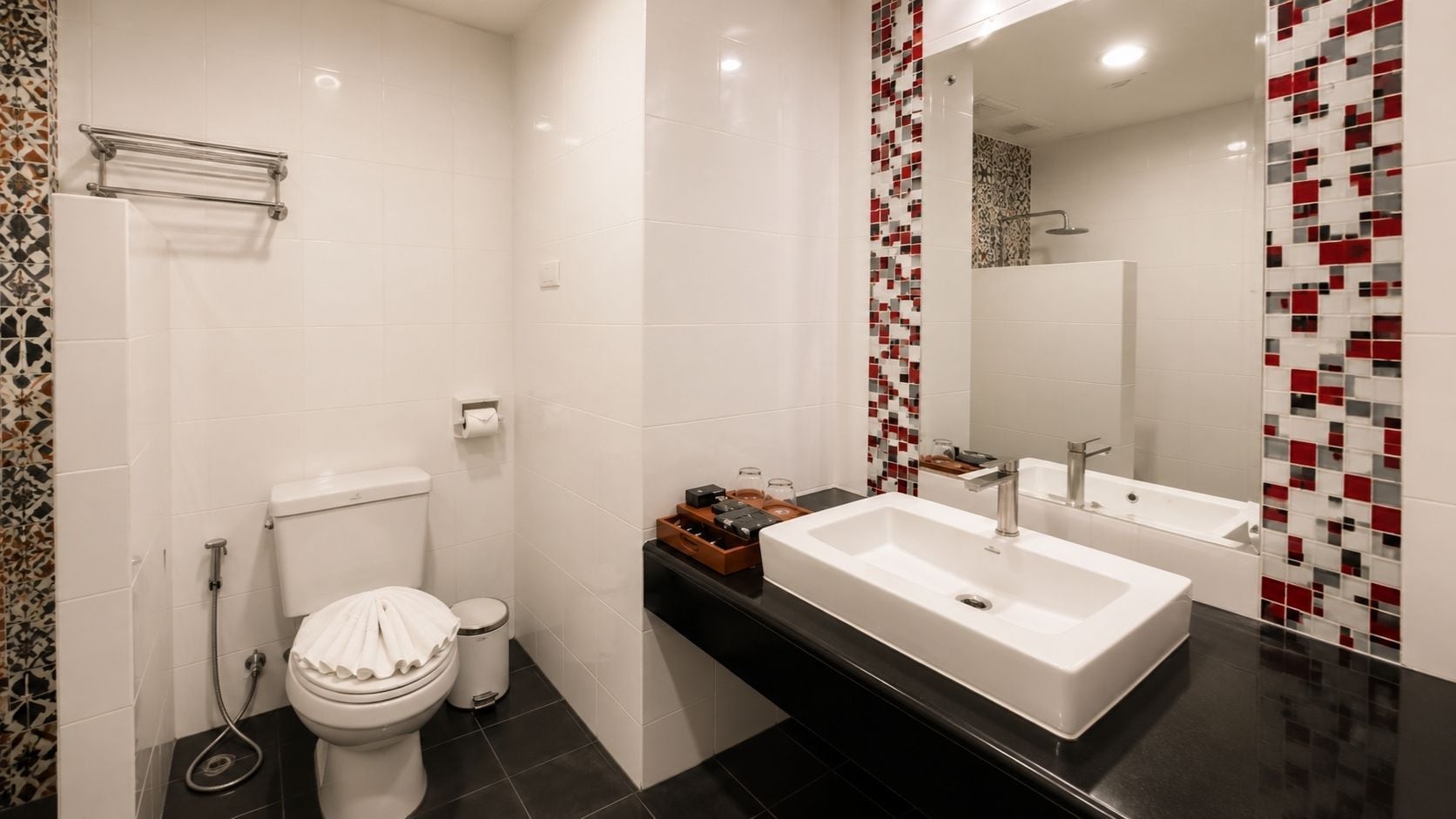 A modern bathroom with a toilet, bidet, and a vanity with a sink and mirror.