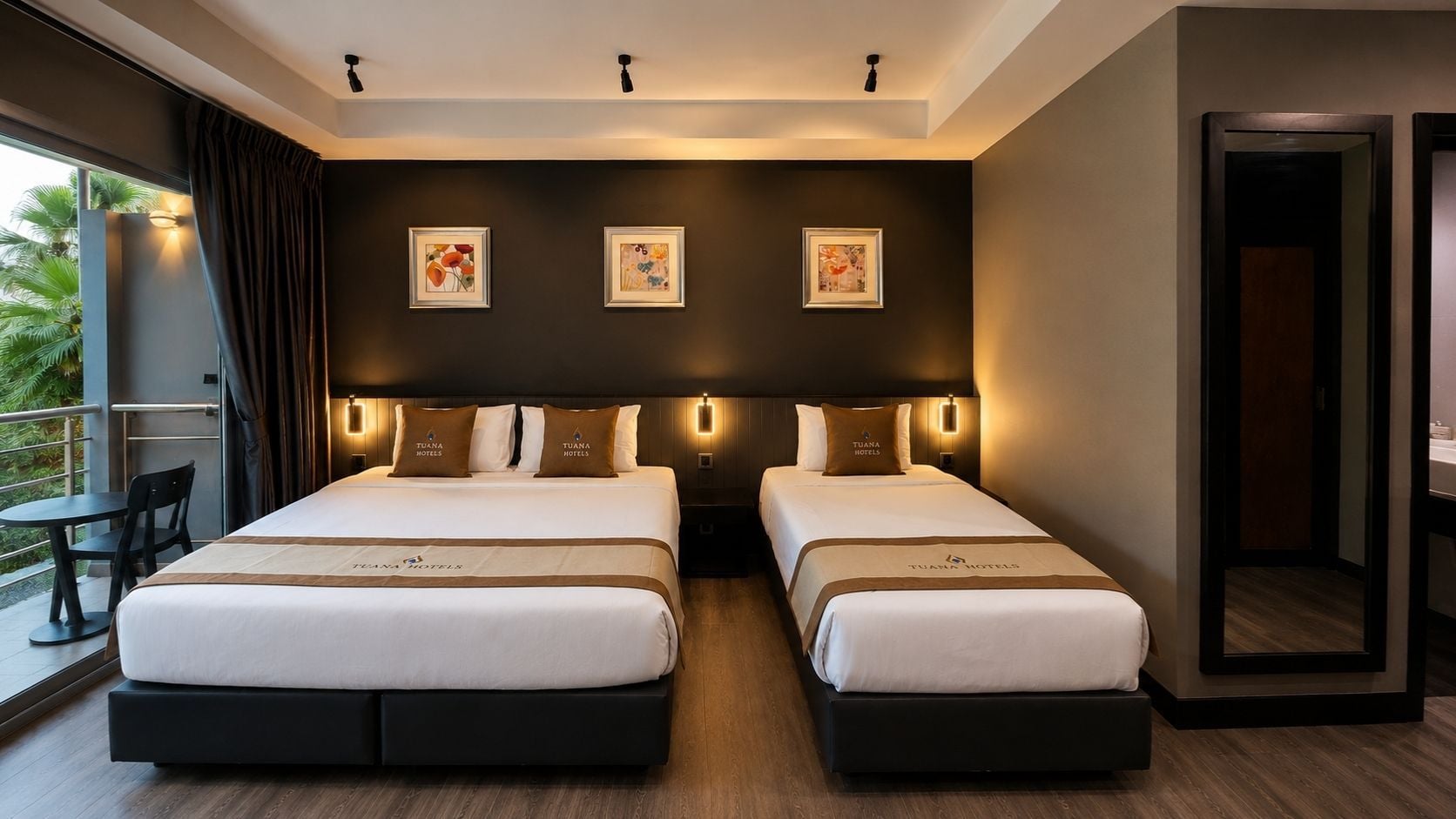 A hotel room with two beds, a balcony, and artwork on the wall.