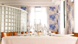 A dining area with a table set for a meal, surrounded by chairs. - Hotel Amparo (Machico)