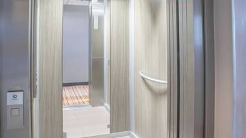 An elevator with a metallic finish and a control panel labeled "Schindler."