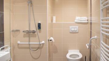 A modern bathroom with a shower, toilet, and handrails.