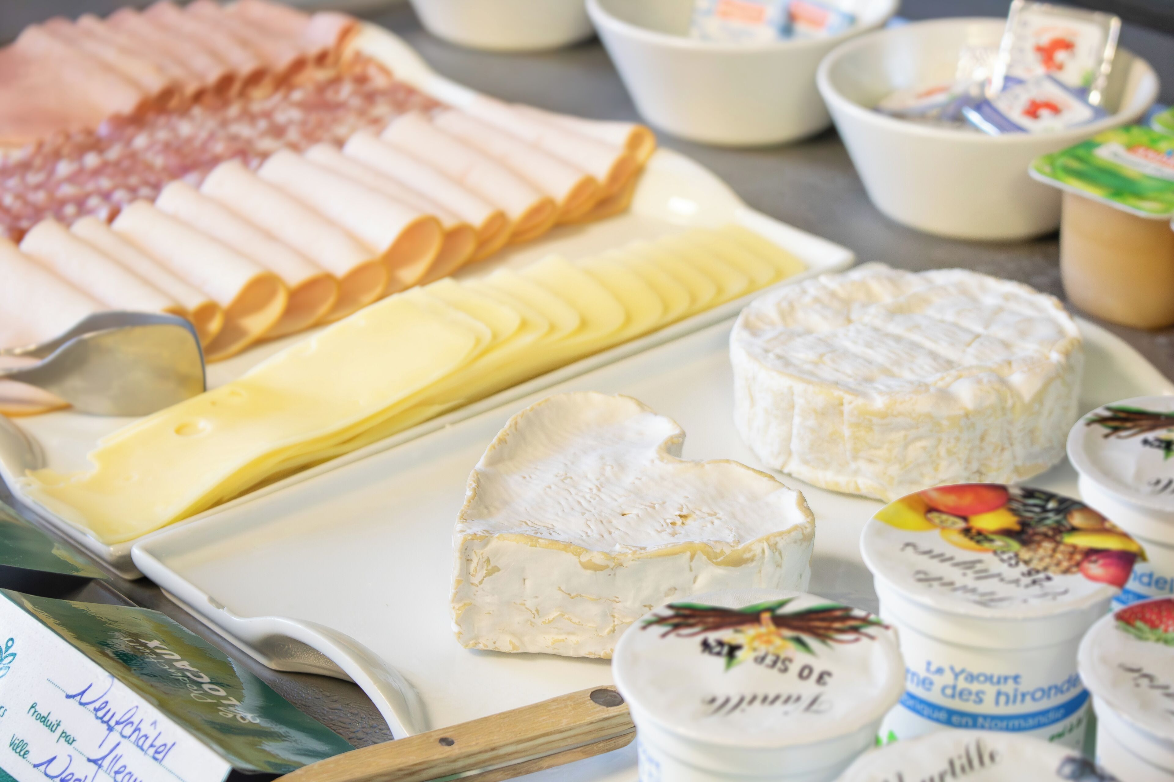 A variety of cheeses and dairy products on a tray.