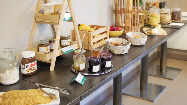 Una mesa de buffet con diversos alimentos y salsas.