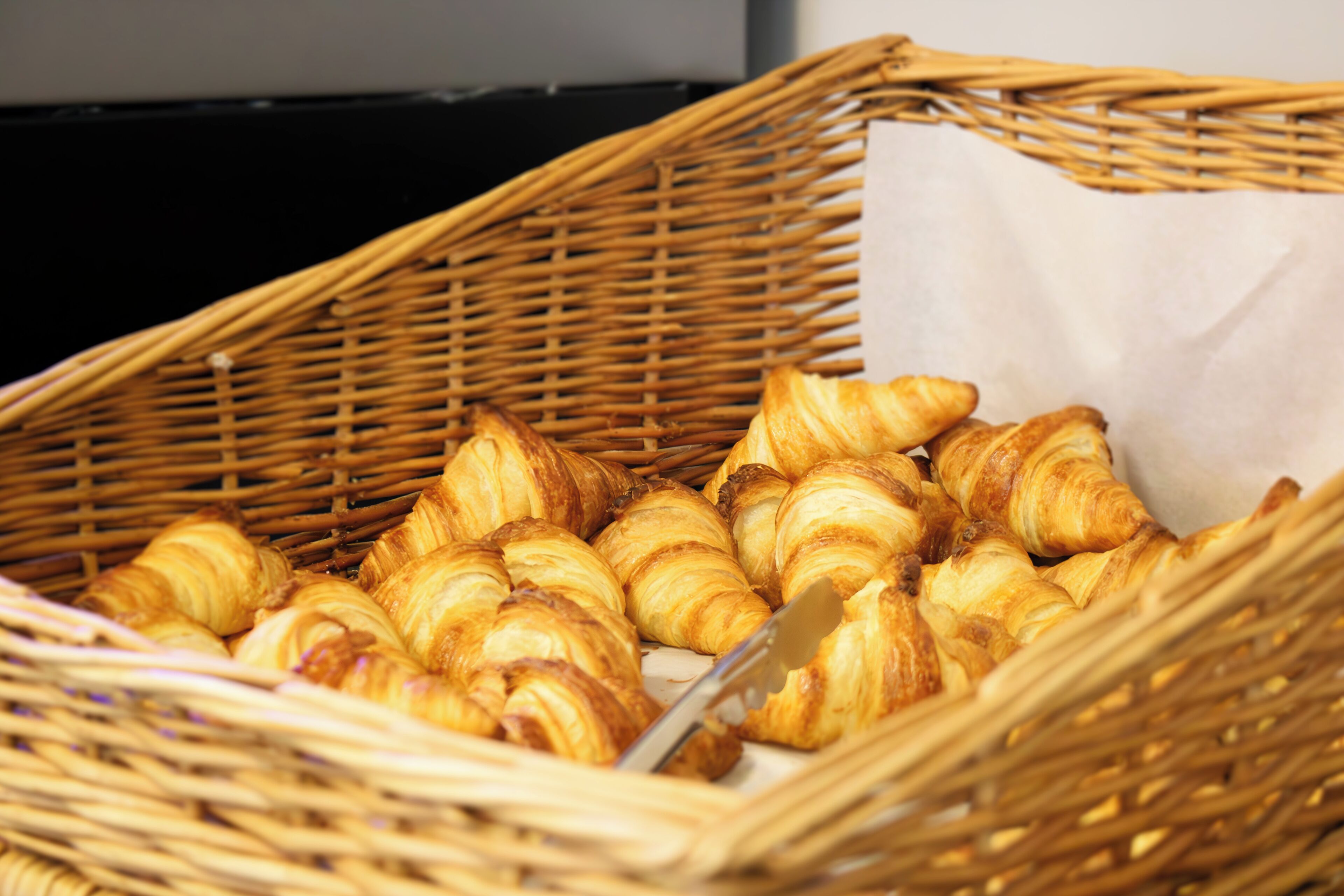 A wicker basket filled with croissants.