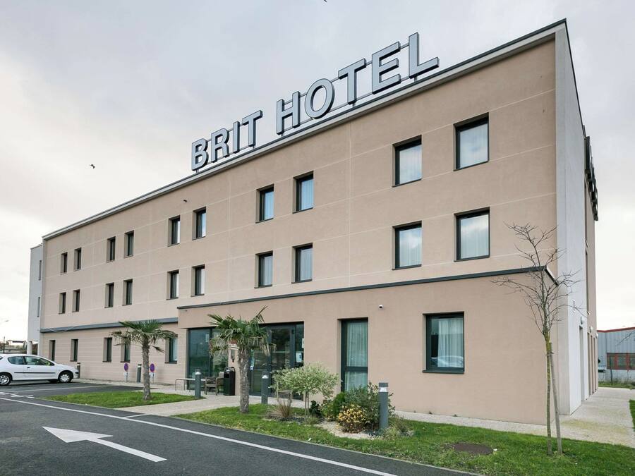 A modern hotel building with a sign reading 'BRIT HOTEL' on the facade.