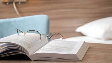Un libro abierto con gafas encima, sobre una superficie de madera.