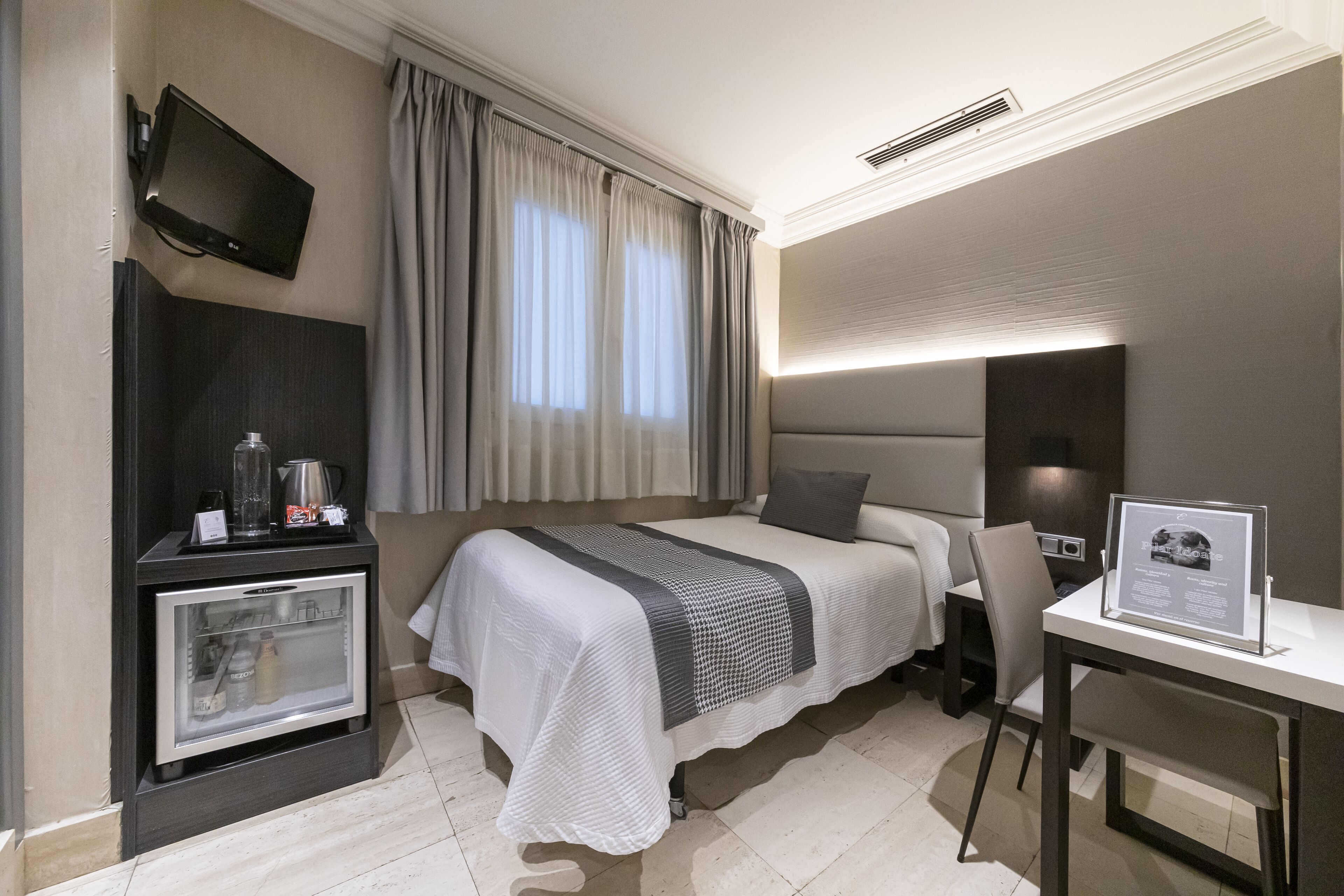 basic single room interior | free minibar items, in-room safe, desk, blackout curtains