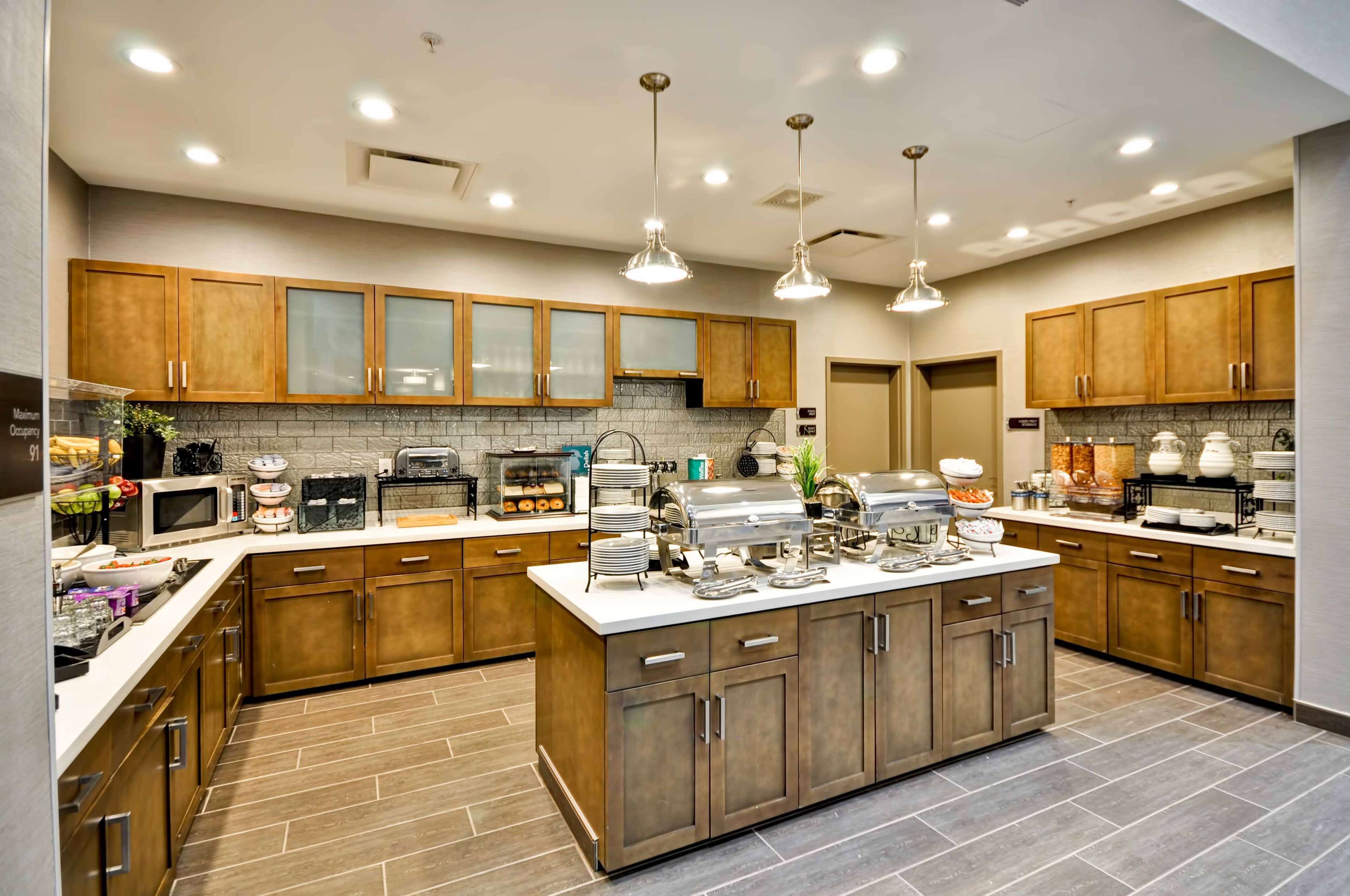 Una cocina moderna con armarios de madera, una isla central y varios electrodomésticos.