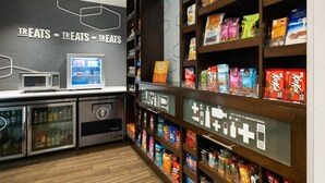 Een snackautomaat met verschillende verpakte producten en een magnetron.