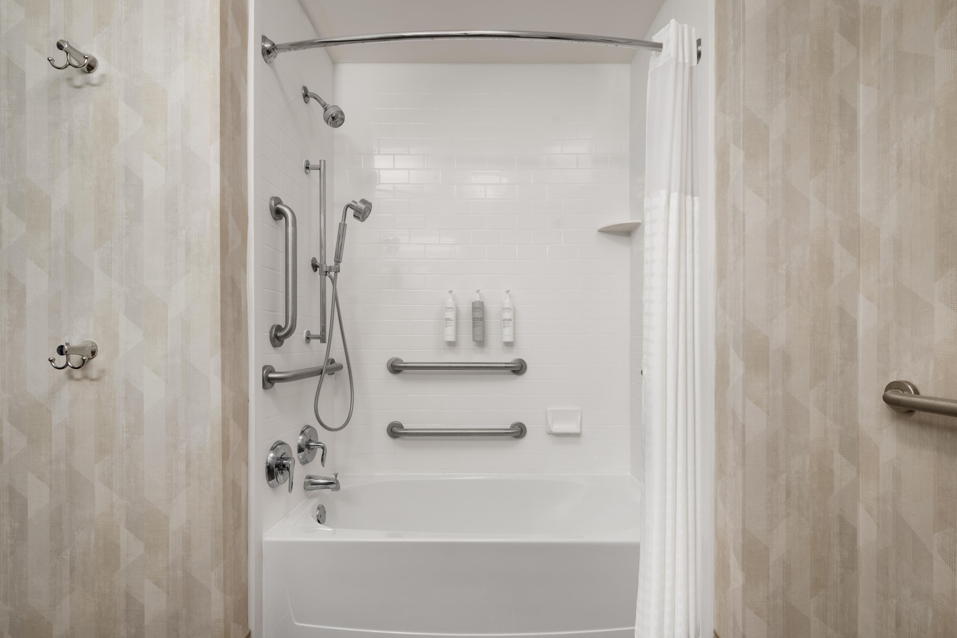 A modern bathroom with a walk-in shower, grab bars, and a toilet with a raised seat.