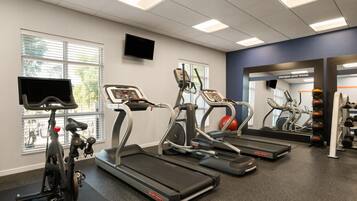 A gym with treadmills, an elliptical, and a stationary bike.