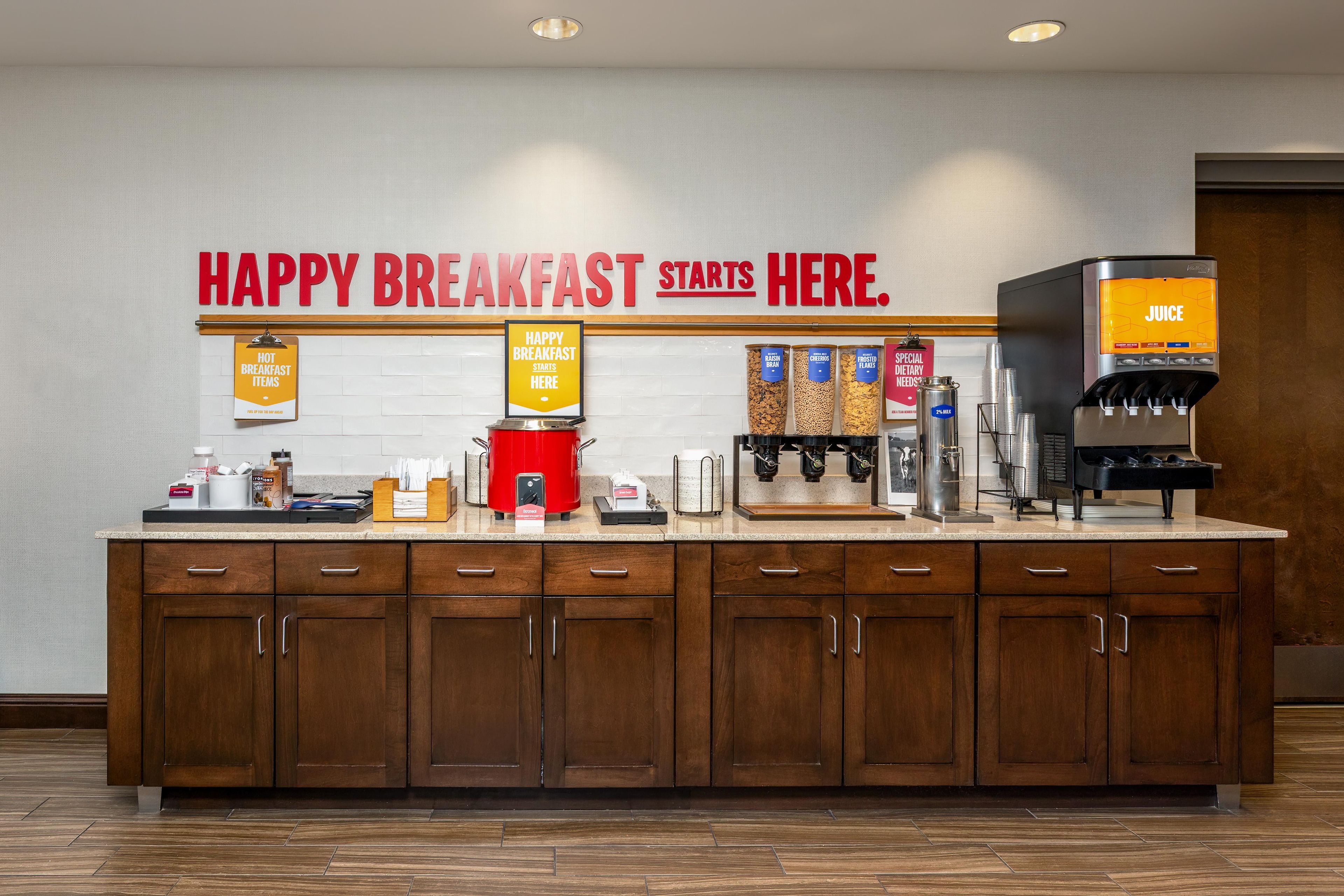 A breakfast bar with a sign reading 'HAPPY BREAKFAST STARTS HERE.'