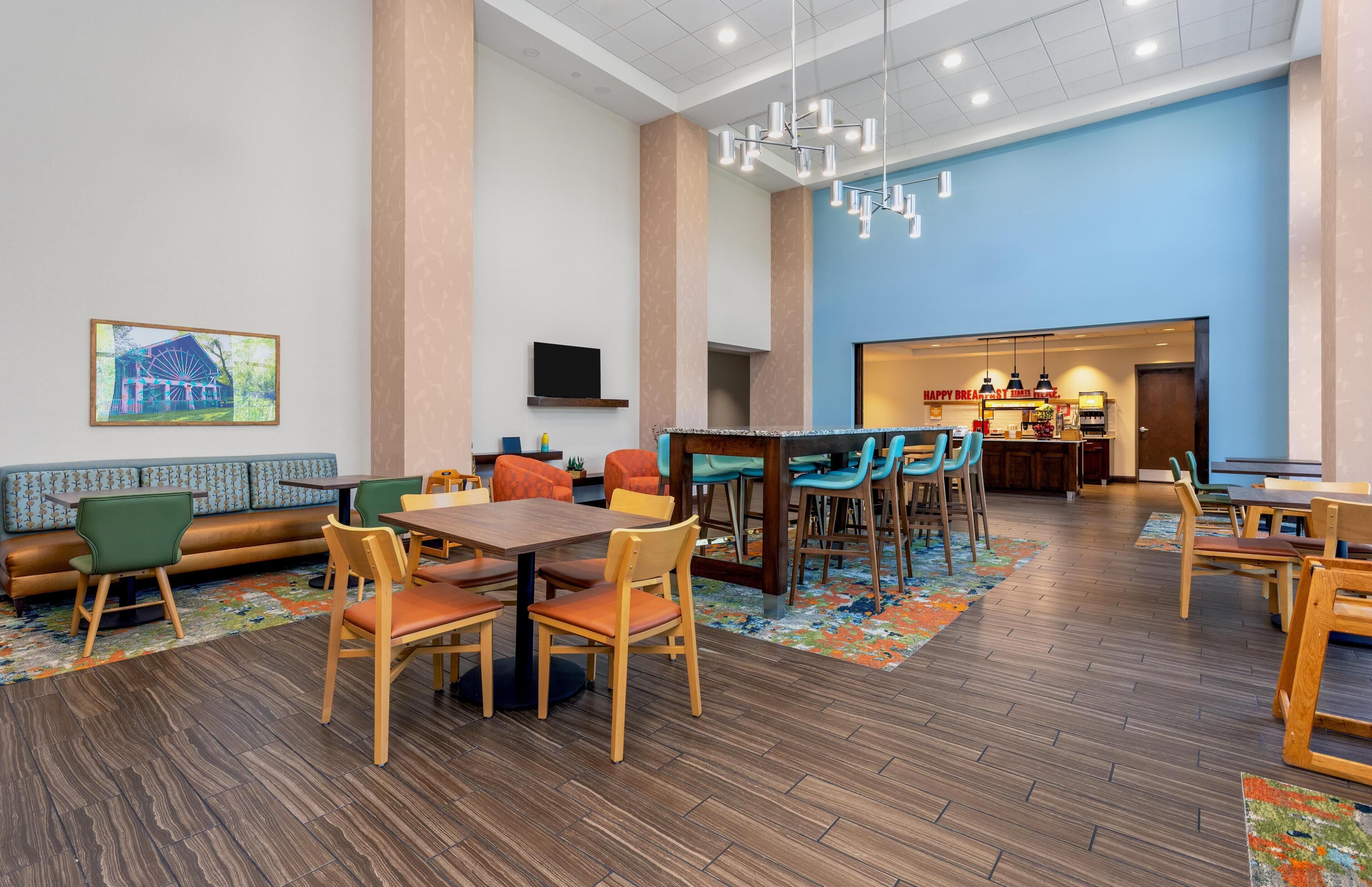 Eine Hotelhalle mit Sitzgelegenheiten, einer Bar und einem Fernseher.