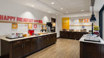 A breakfast area with a sign reading 'HAPPY BREAKFAST STARTS HERE.'