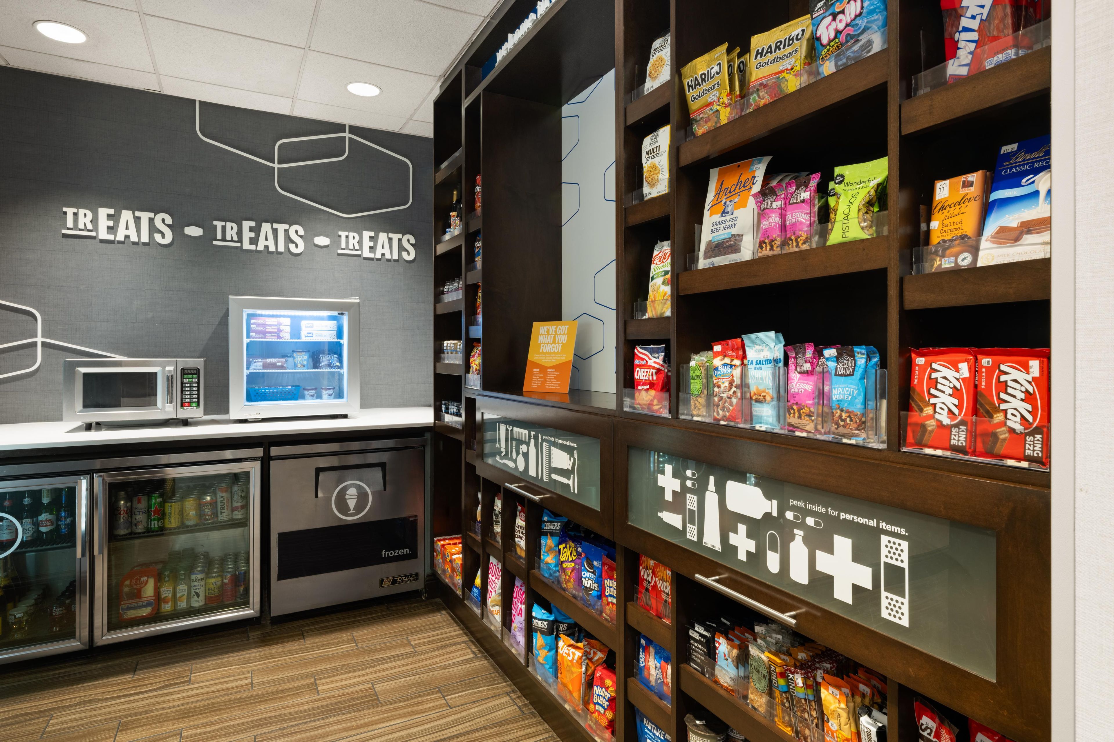 A snack display with various packaged foods and a microwave.