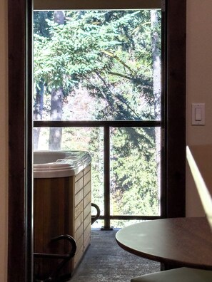 A bathroom with a large window, a bathtub, and a shower area.