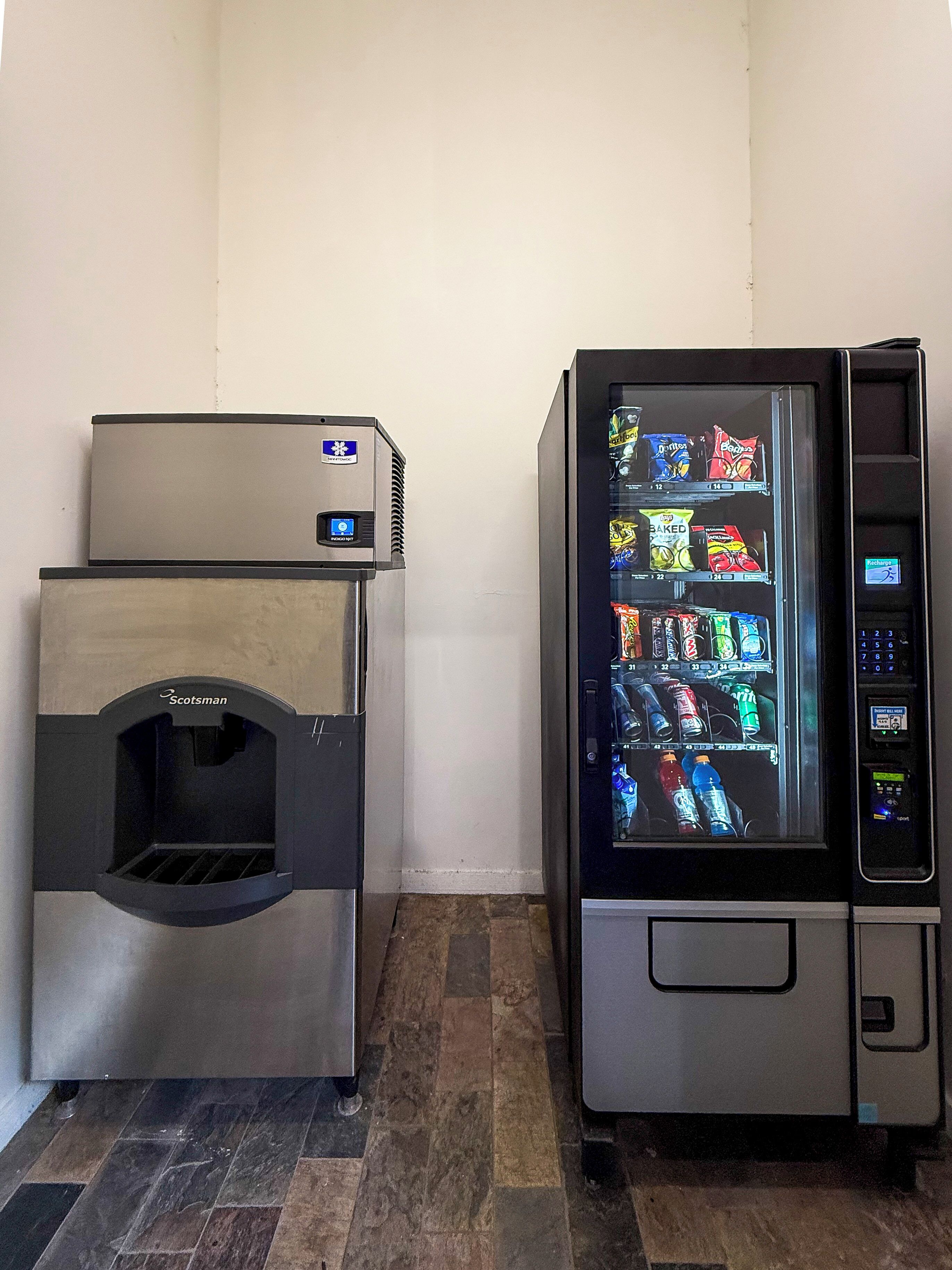 A vending machine and a coffee machine in a corner.