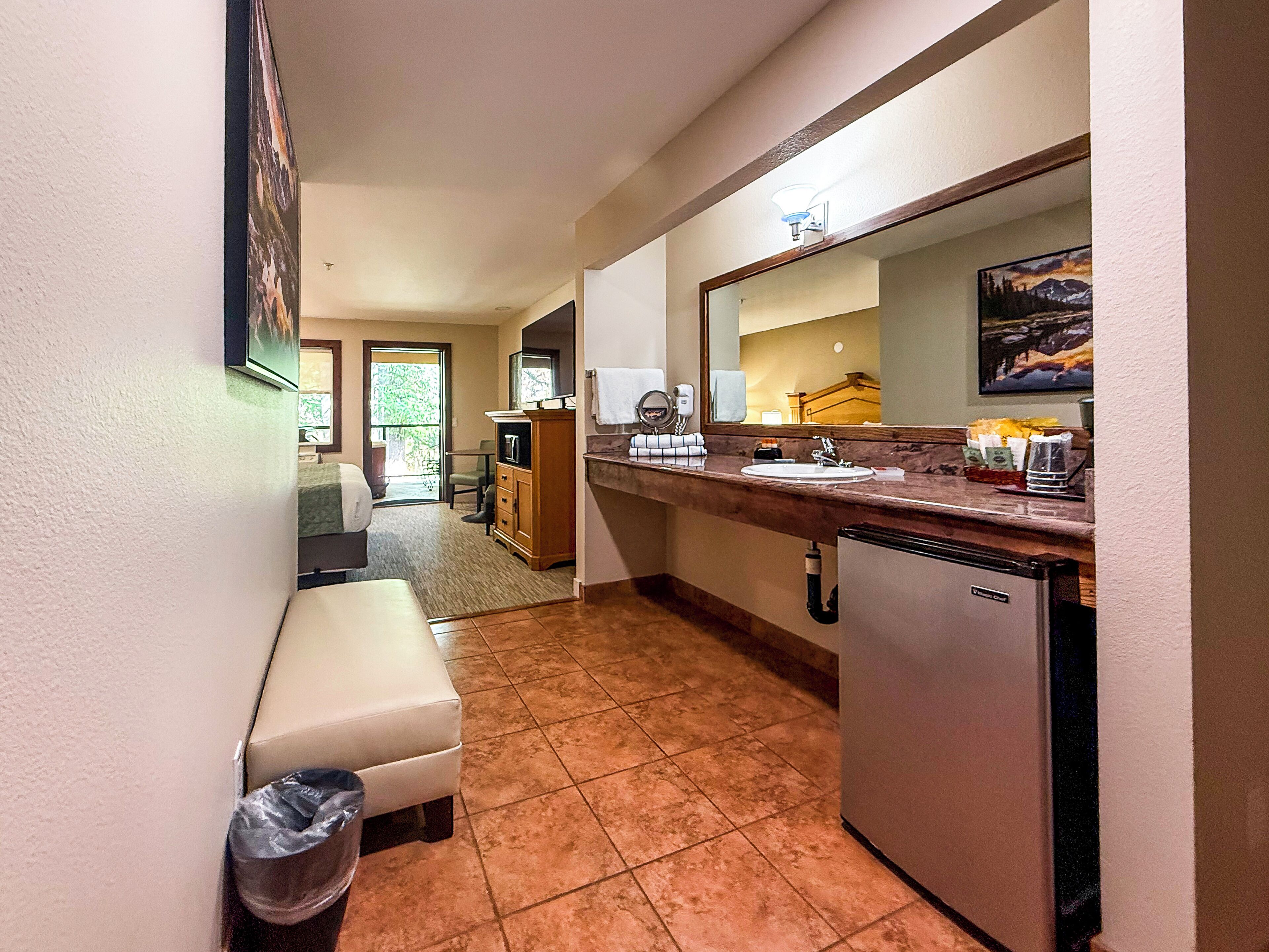 Habitación de hotel compacta con kitchenette, un pequeño espacio para sentarse y vistas al exterior.