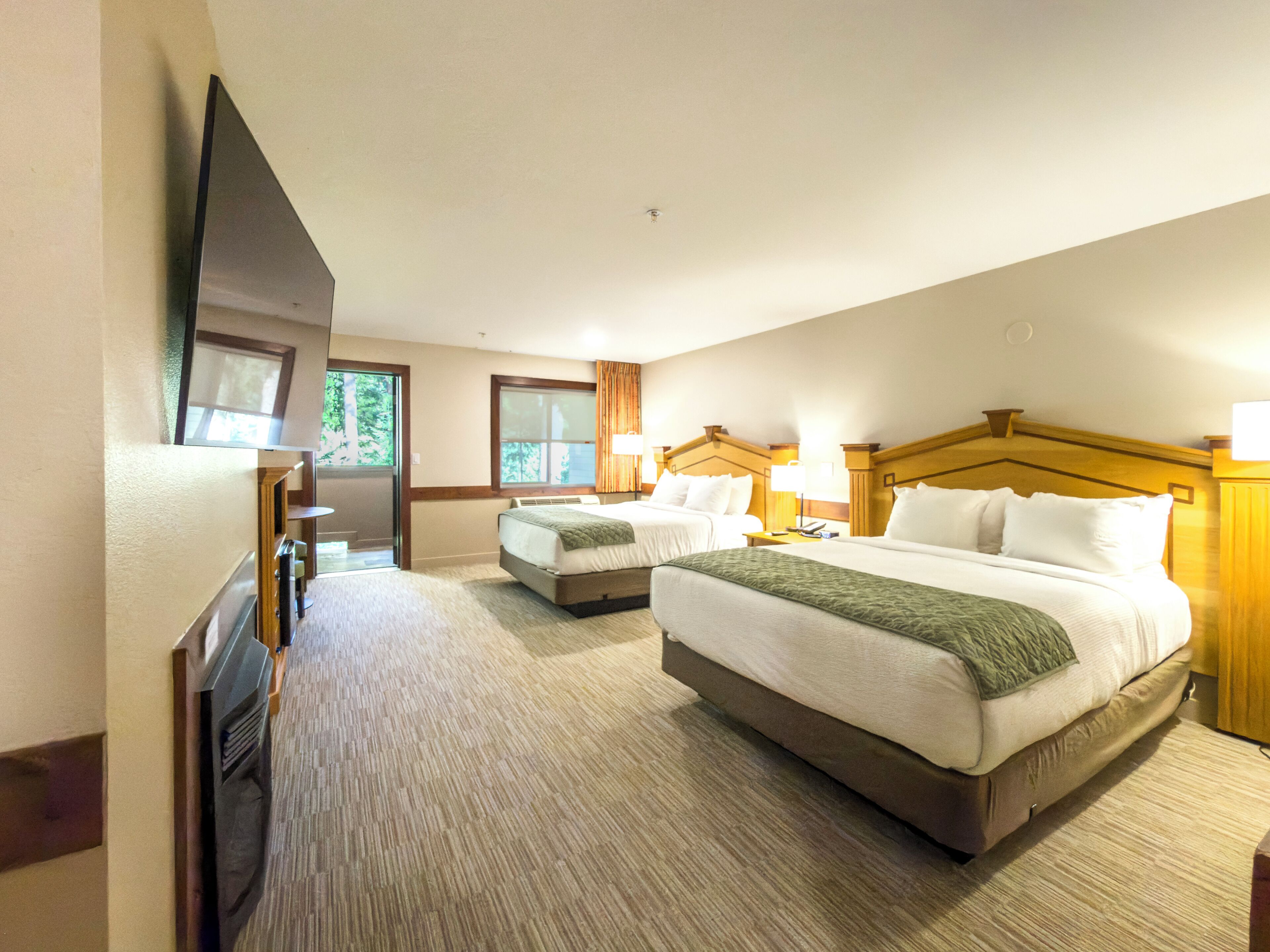 Une chambre d’hôtel avec deux lits, une télévision et une fenêtre avec des rideaux.
