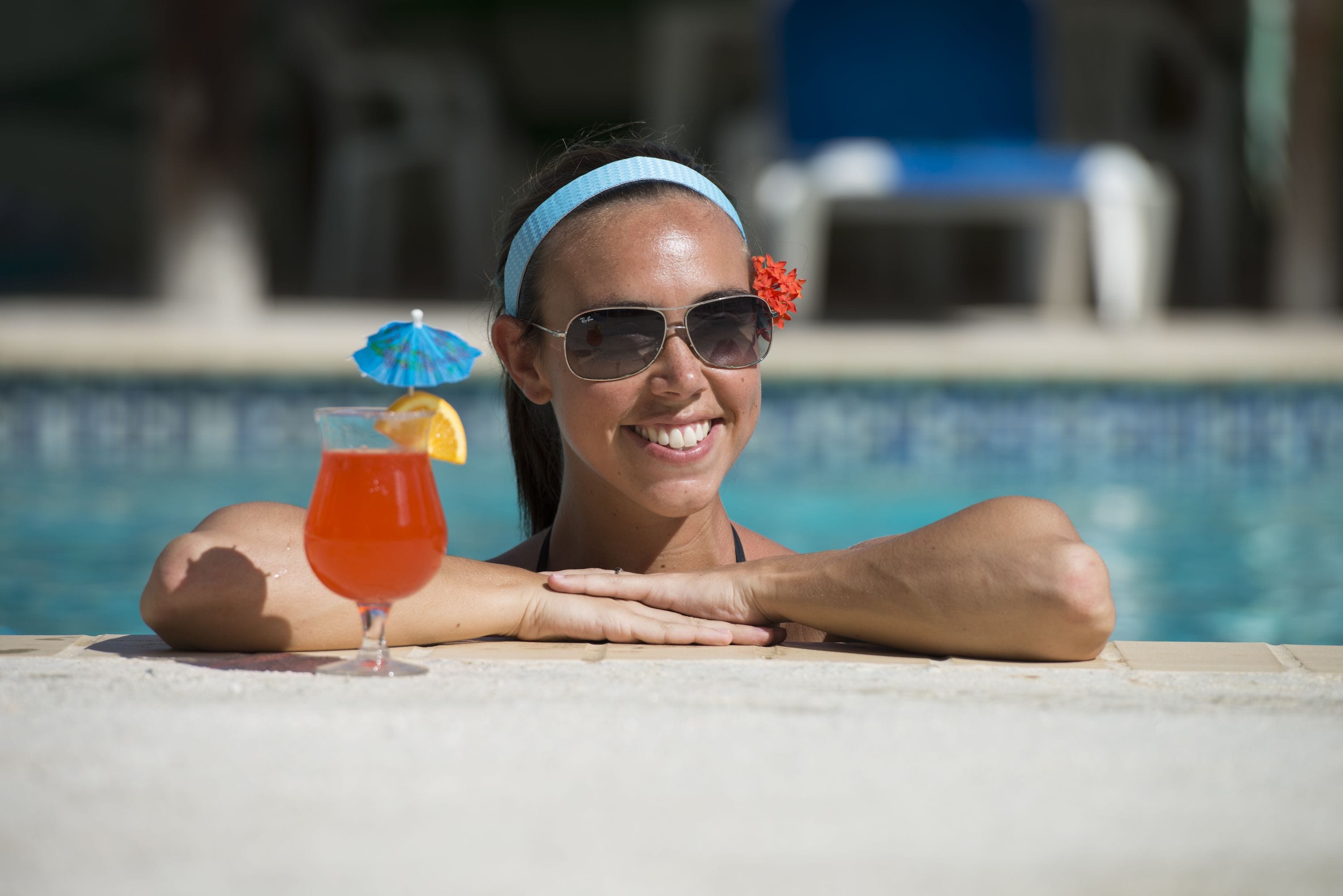 A poolside setting with a clear view of the pool and lounge chairs in the background.