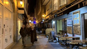 Una calle estrecha con mesas y sillas en la terraza de un restaurante.