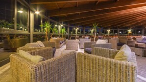 An outdoor seating area with wicker furniture and potted plants.