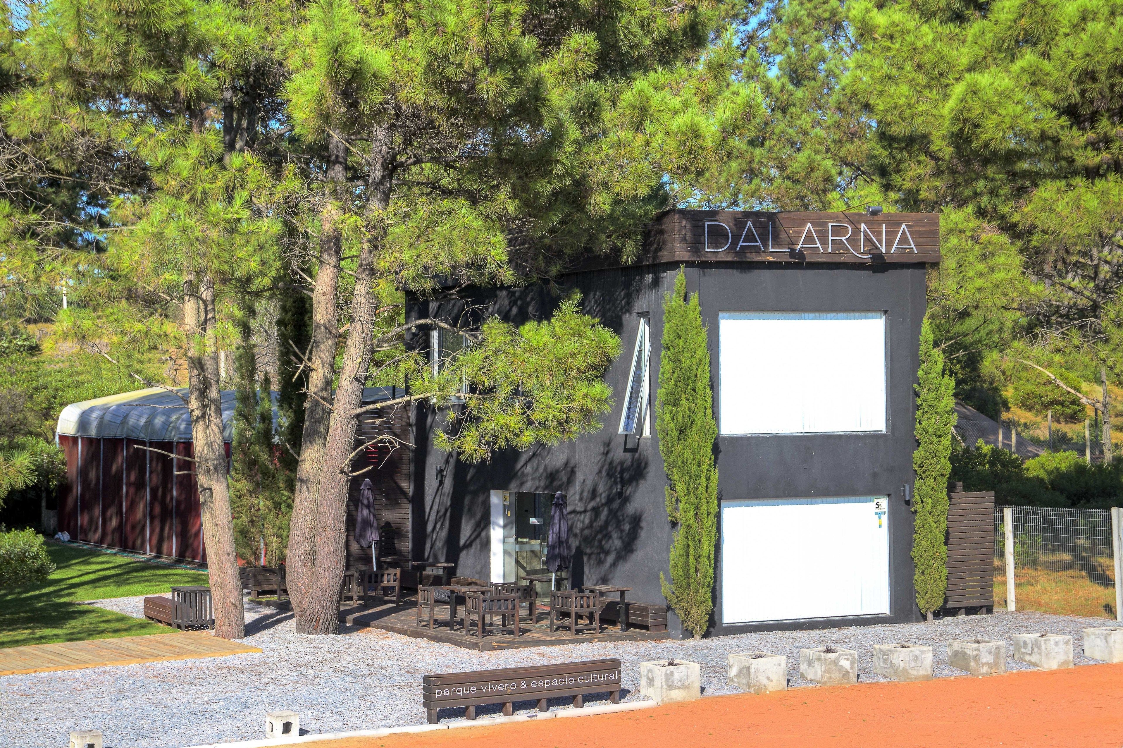 A building labeled "DALARNA" with a covered outdoor seating area and a gravel path.