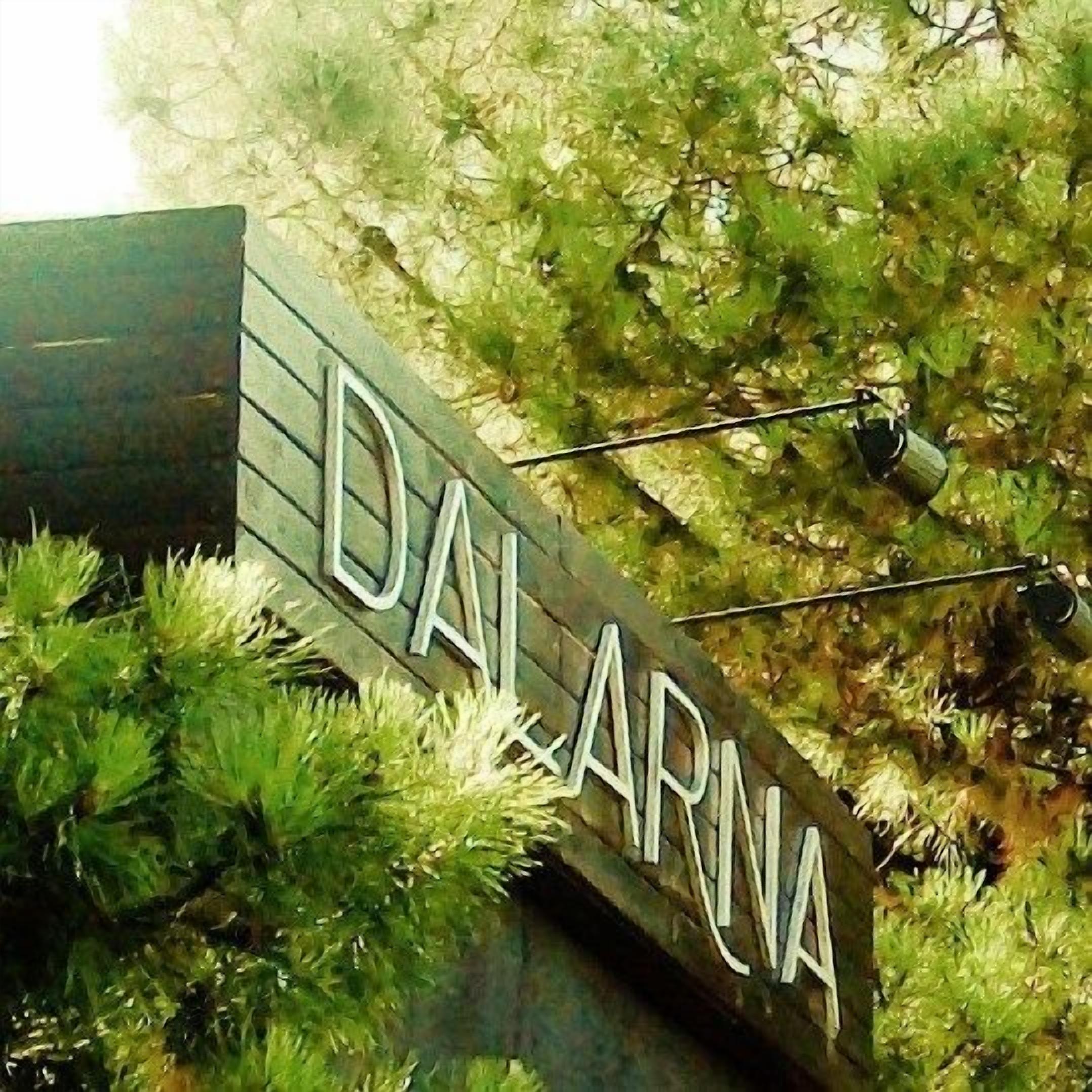 A sign with the name 'DALARNA' mounted on a structure with greenery around it.