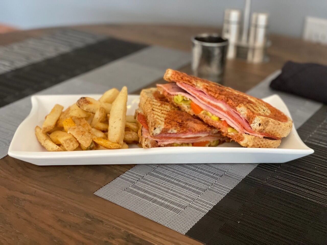 Un plato con un sándwich y papas fritas sobre una mesa.