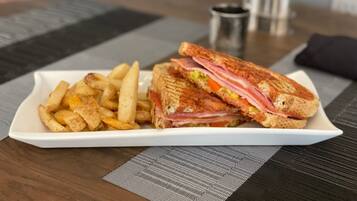 Un plato con un sándwich y papas fritas sobre una mesa.