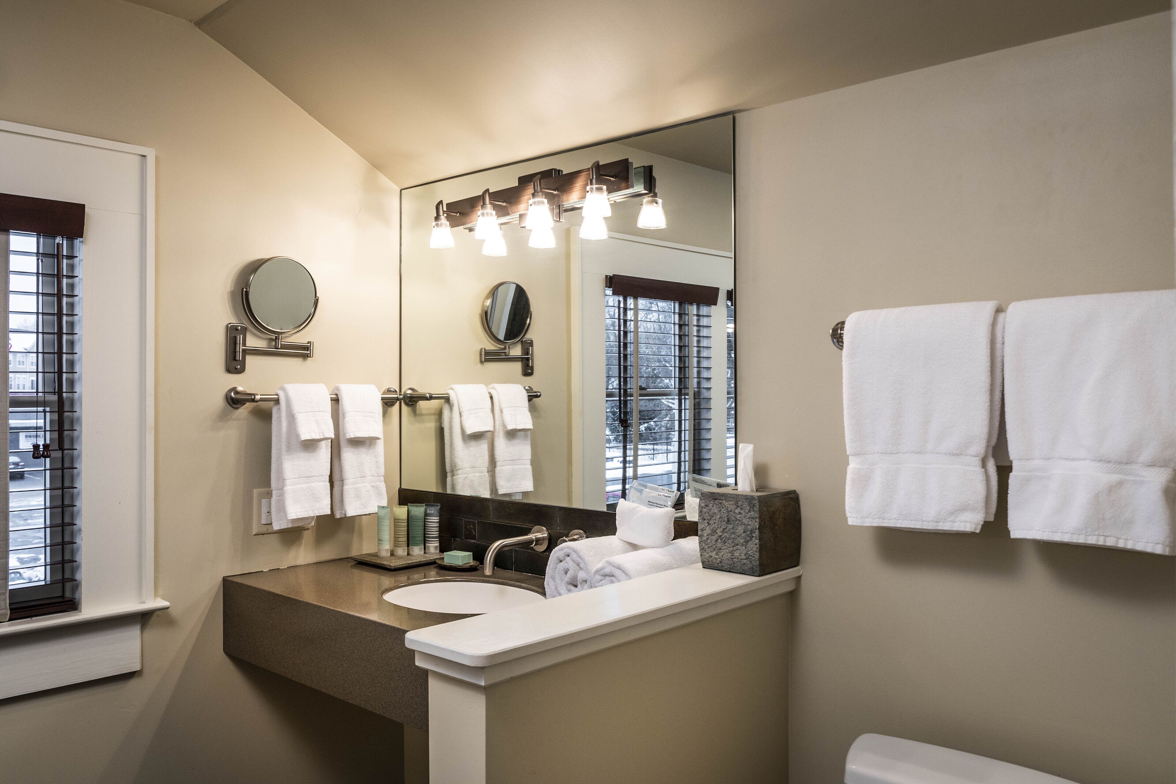 A bathroom with a sink, mirror, and towel rack.