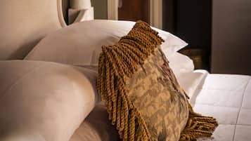 A neatly made bed with a patterned throw pillow and a headboard with a decorative finial.