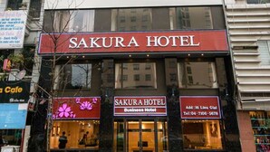 Un edificio a più piani con un cartello ben visibile che riporta la scritta "SAKURA HOTEL".