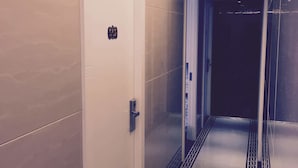 A hotel corridor with a skylight, a door with a sign, and a patterned floor. - Seasons Hotel - Causeway Bay (Hong Kong)