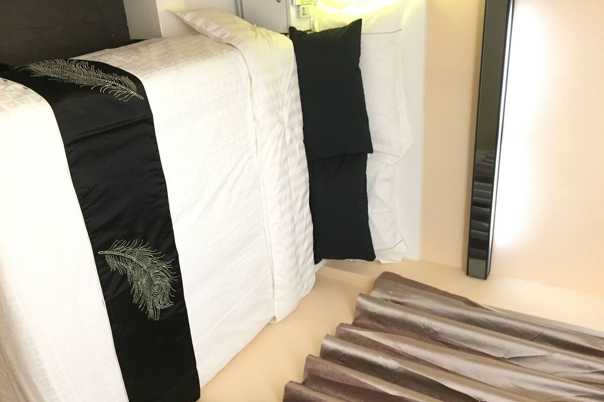 Ein Hotelzimmer mit einem Bett, einem Nachttisch und einem Spiegel.