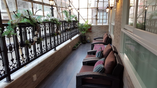A covered outdoor seating area with wicker furniture and potted plants. - Seasons Hotel - Causeway Bay (Hong Kong)