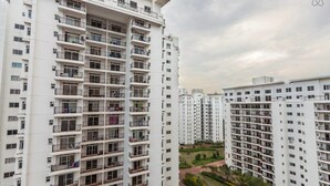 Un edifici residencial alt amb nombroses balconades i una zona de jardí paisatística al primer pla.