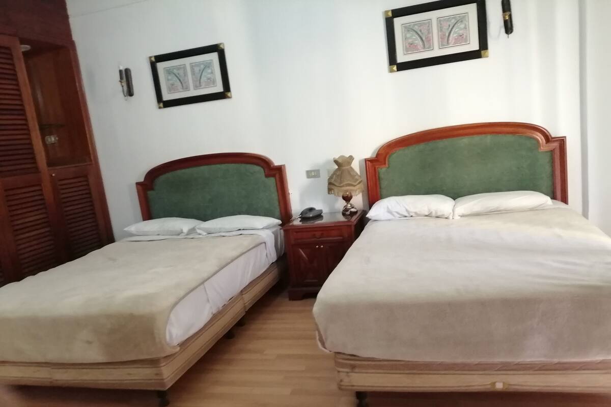 Minibar, escritorio, cortinas blackout y tabla de planchar con plancha
