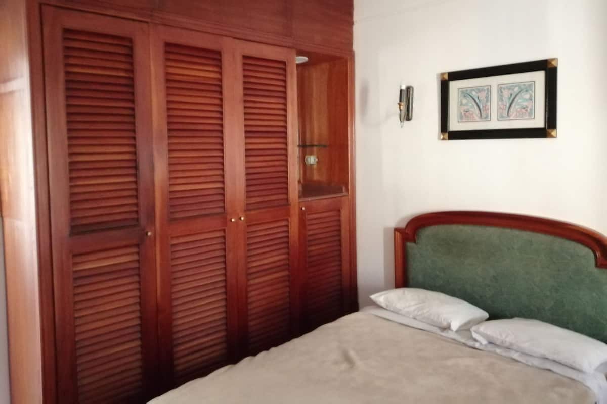 Minibar, escritorio, cortinas blackout y tabla de planchar con plancha