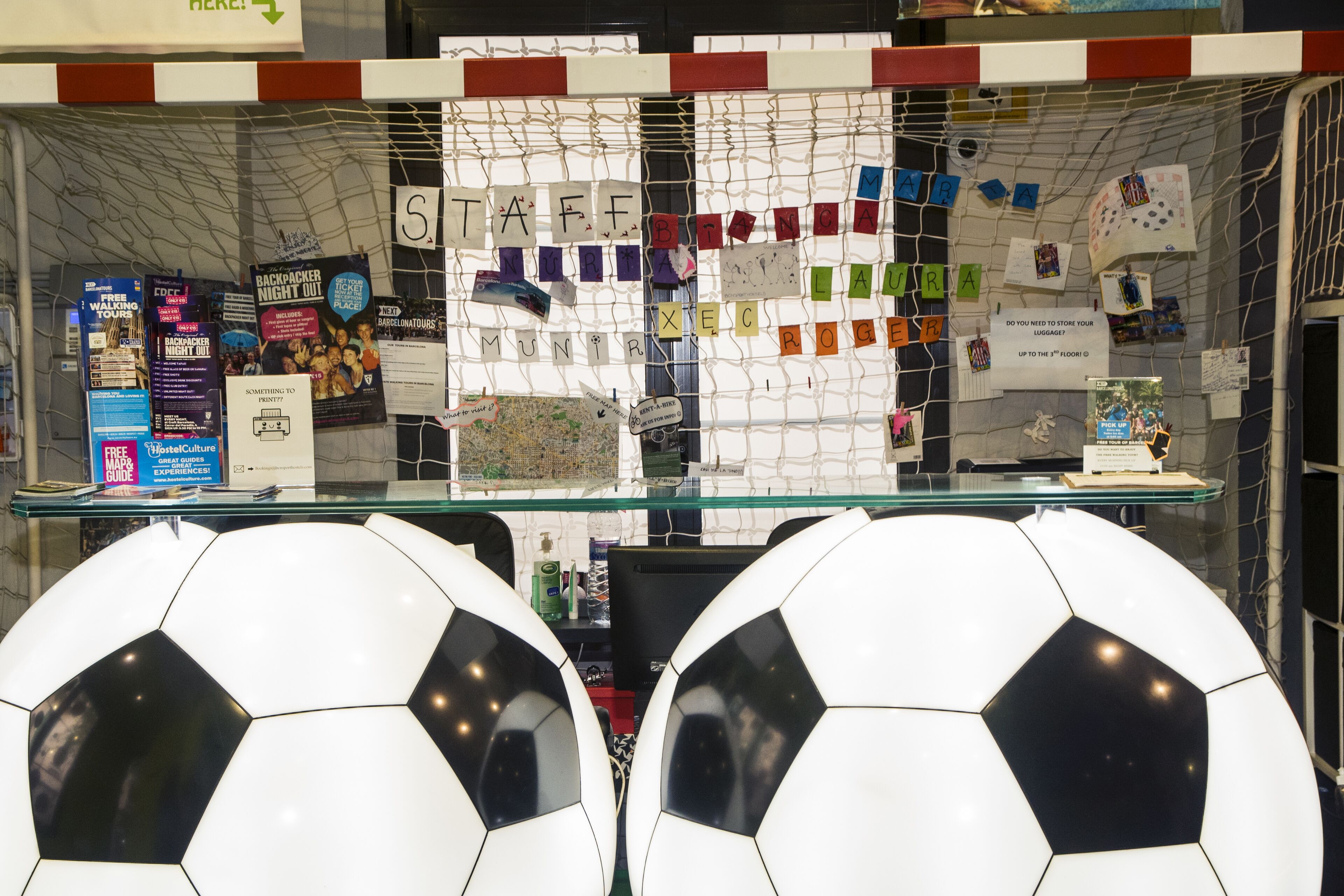 A glass display case with soccer balls and various travel-related items.