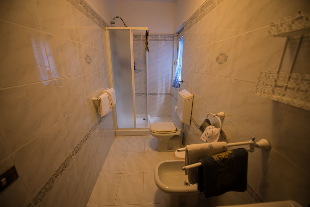 A bathroom with a shower, toilet, and bidet.