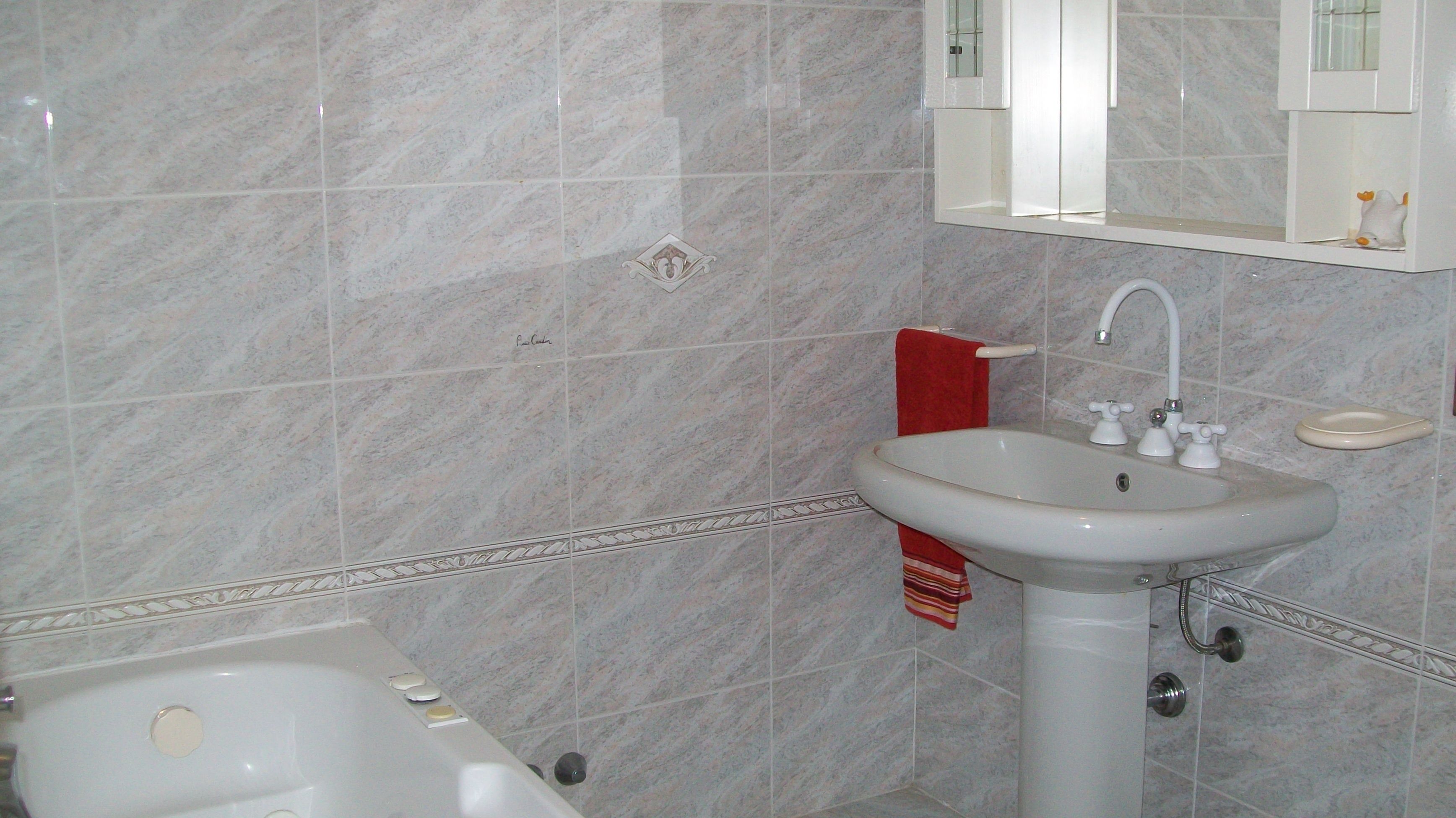 Un bagno con vasca, lavabo e specchio.