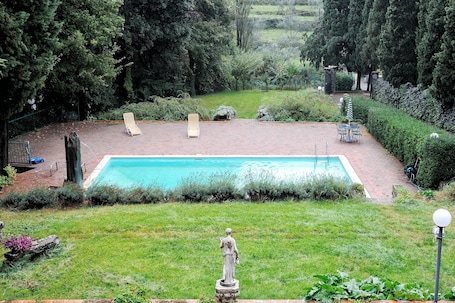 Una piscina al aire libre, sillones reclinables de piscina
