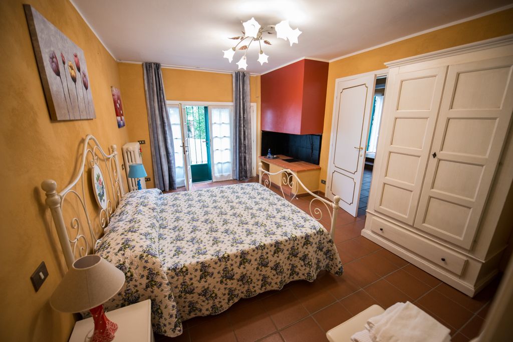 Een slaapkamer met een bed, bureau, televisie en een kledingkast.