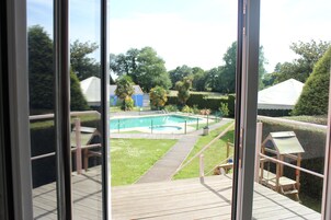 Una piscina al aire libre, sillones reclinables de piscina