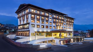 A multi-story hotel with a traditional architectural style, featuring balconies and large windows.