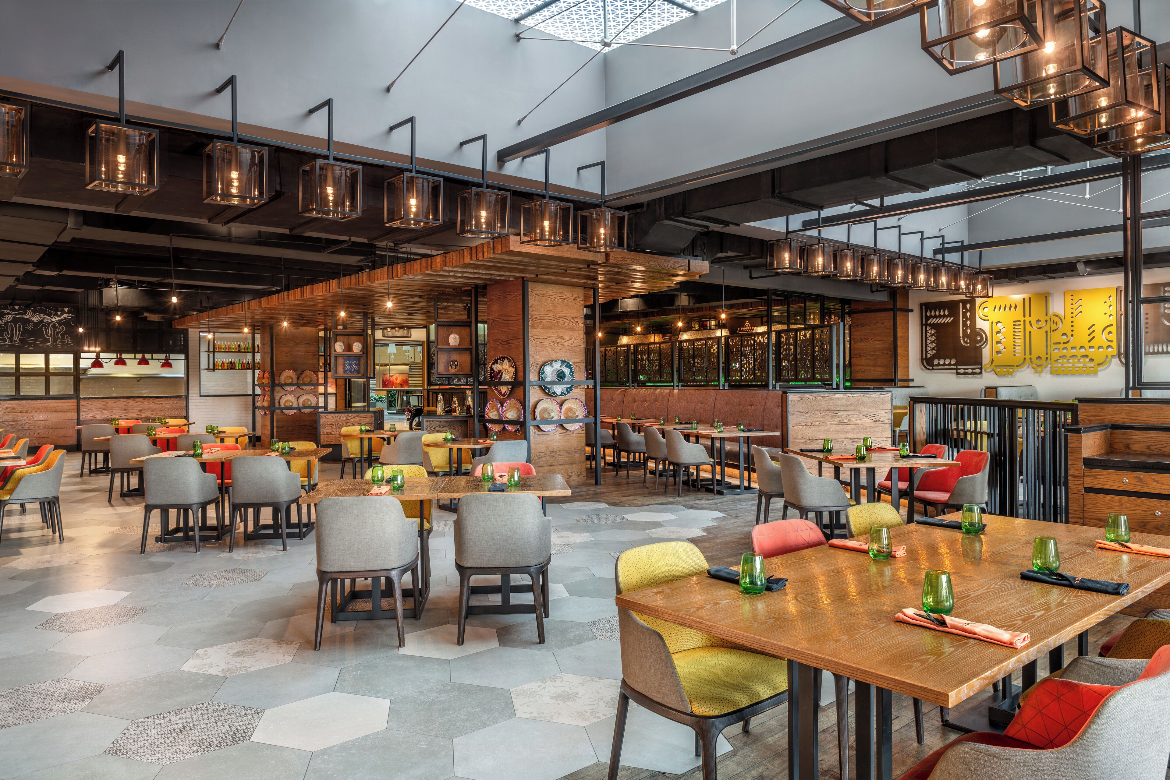 A spacious restaurant with high ceilings, exposed beams, and a variety of seating options including tables and chairs.